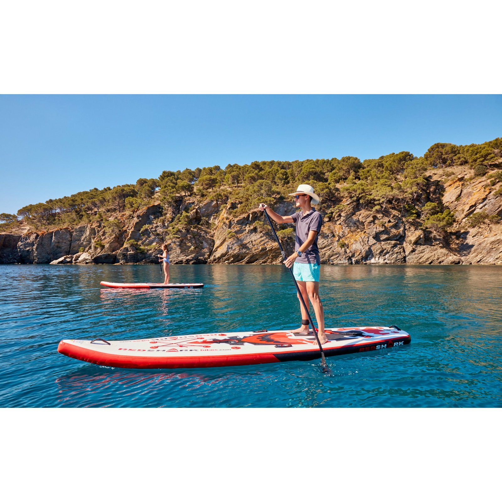 Twee peddelaars staand op Red Shark SUP boards