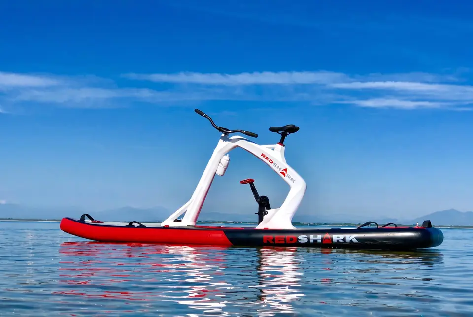 Witte Red Shark waterfiets op rood board op stil water onder een blauwe lucht